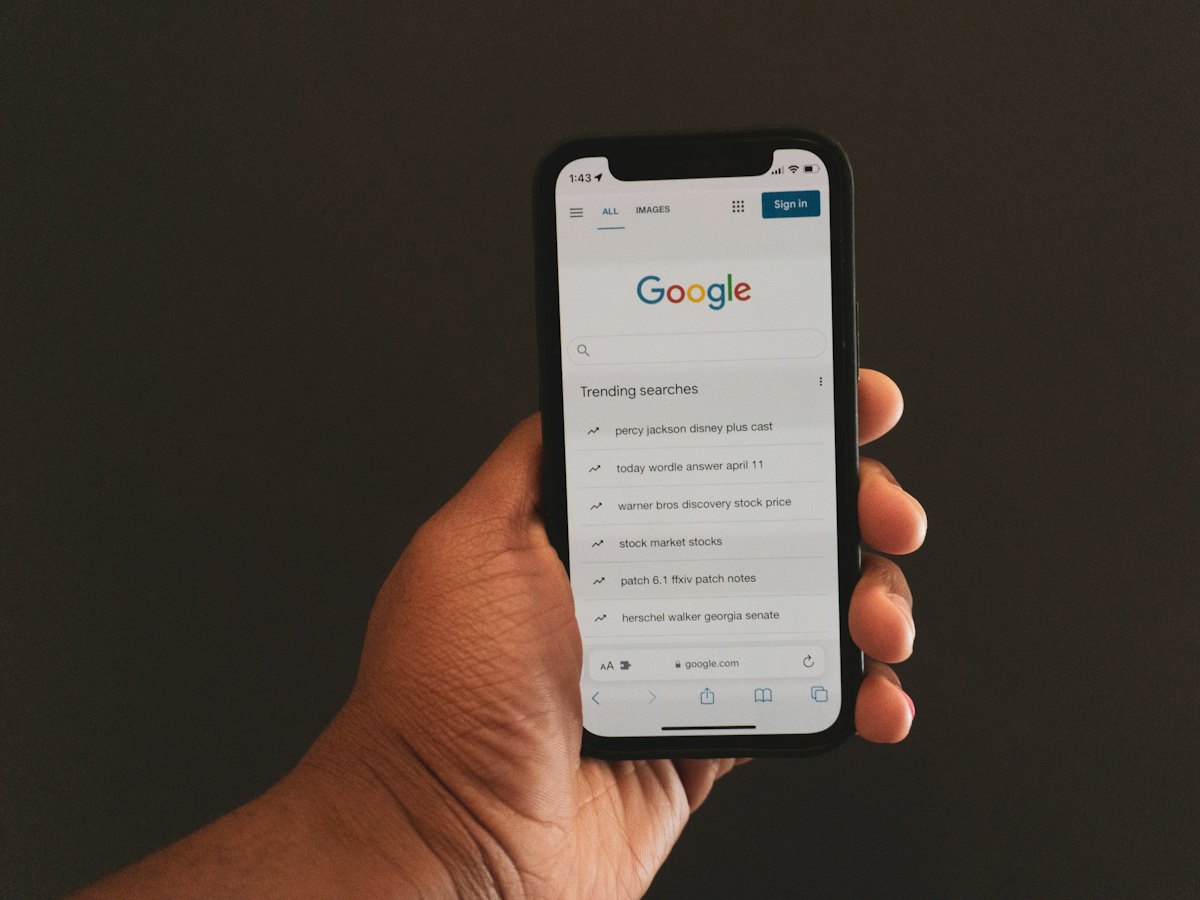 Hand holding a phone with Google search open