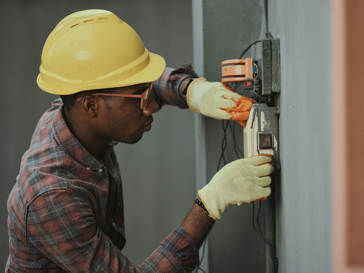 Electrician in a hard hat fixing wiring
