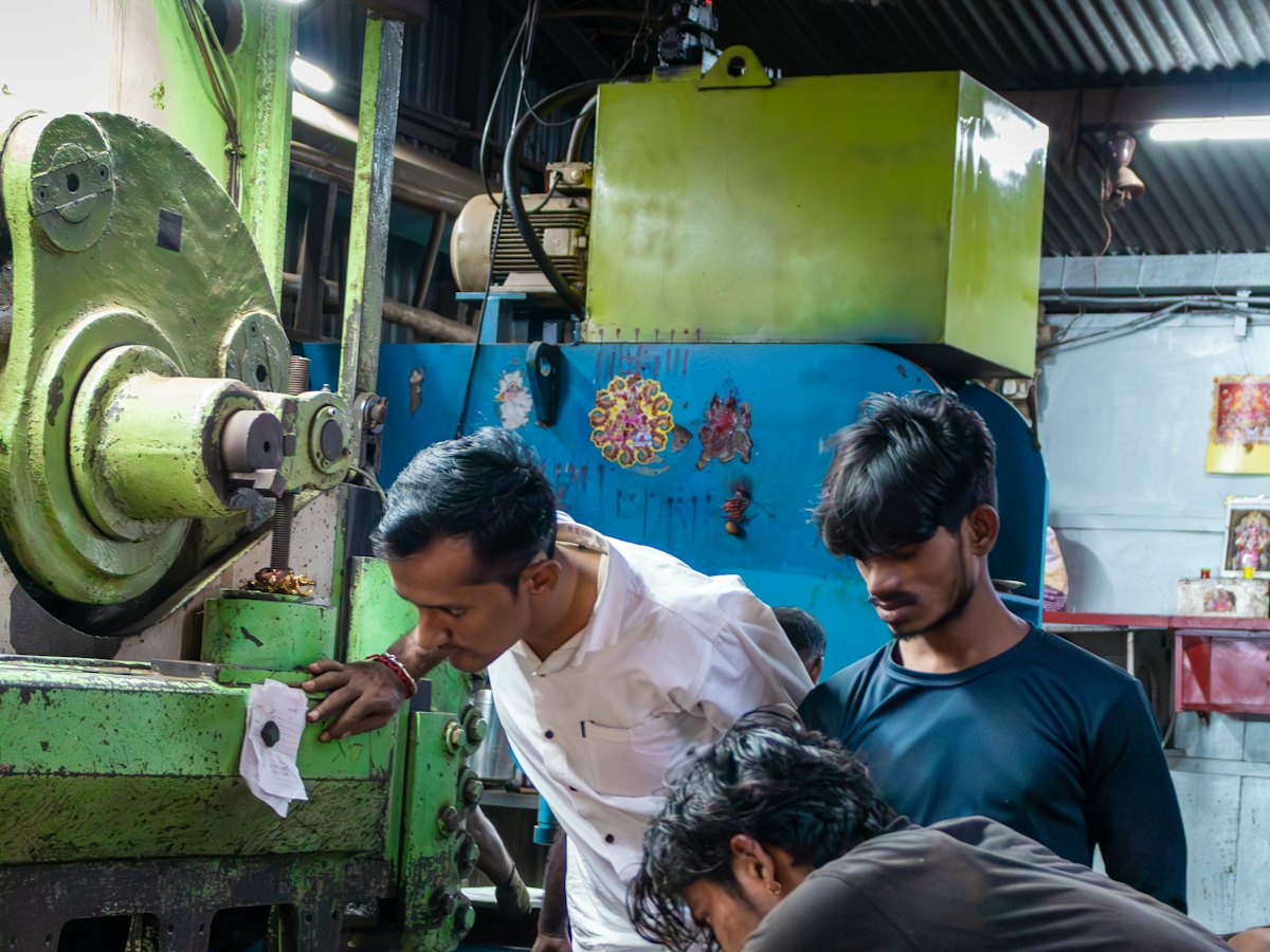 Workers operating a machine in an Indian factory