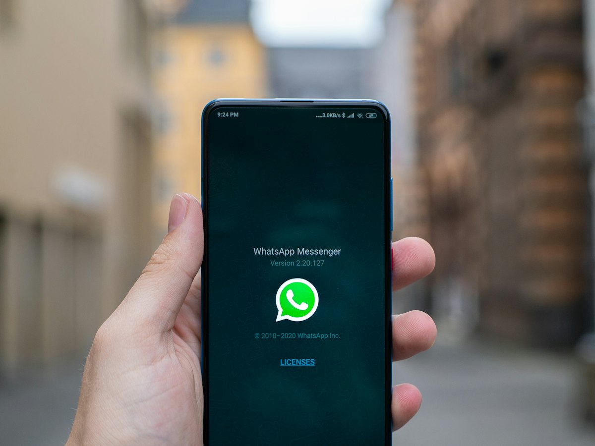 Hand holding a phone with WhatsApp open
